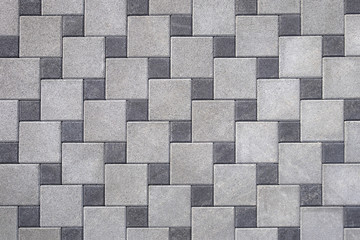 Part of urban sidewalk covered with gray concrete cube elements