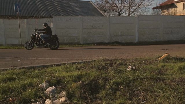 Man Riding old custom cafe-racer Motorcycle on Country Road at autumn sunny day