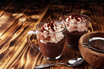 Hot chocolate or coffee with whipped cream in glass.