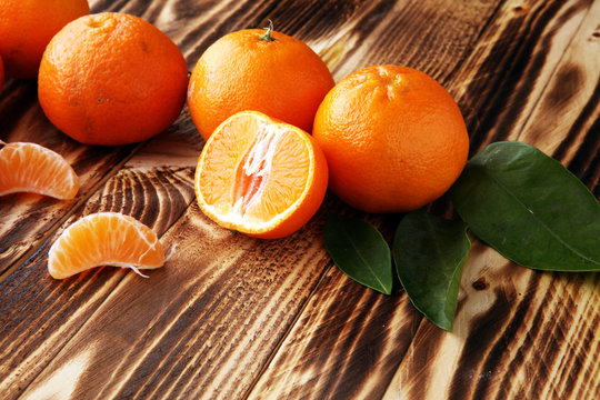 fresh mandarin oranges fruit with leaves on wooden table.
