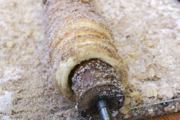 Traditional street food of country Czech Republic. Preparing of Trdelnik - traditional czech bakery. Czech sweet pastry called Trdlo. Trdelnik baking on the street market in Pirna.