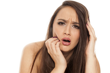 Fototapeta premium A young woman with strong tooth ache on white background