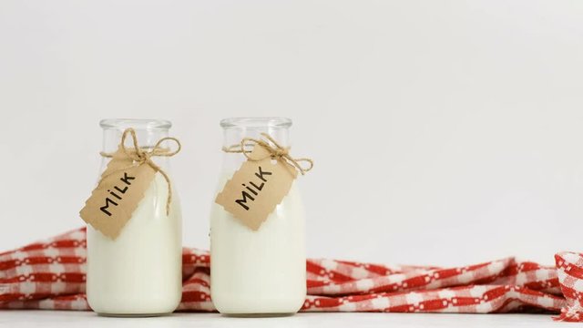 woman hand choosing the best milk from three bottles on white background Only good quality for her family