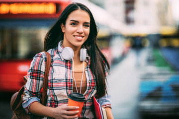 Young woman traveler waiting for a bus on a bus station, travel and active lifestyle concept.