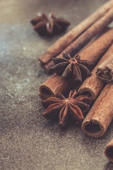 Macro photo of the ends of cinnamon sticks. Very shallow depth of field with the focus on the middle stick. Brown Background.