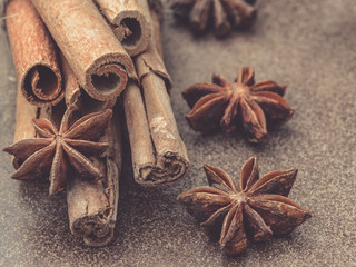 Macro photo of the ends of cinnamon sticks. Very shallow depth of field with the focus on the middle stick. Brown Background.