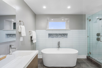 Fototapeta na wymiar Luxury bathroom interior with an oval bathtub stone tiles and with glass shower