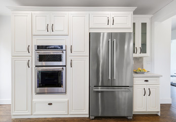 Modern kitchen interior with fitted oven, microwave and refrigerator.