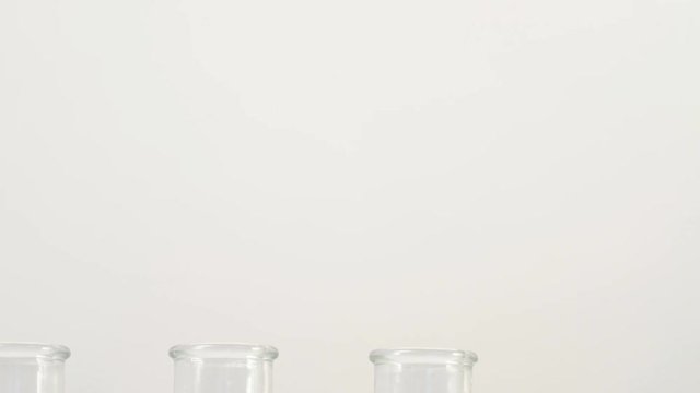 three milk bottles on white background without tags. Slide shot from bottom up. Copy space concept