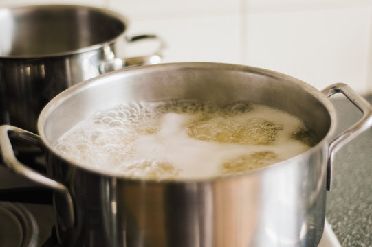 Close Up Of Cooking Pot On Stove Top With Boiling Water Inside While Cooking Spaghetti