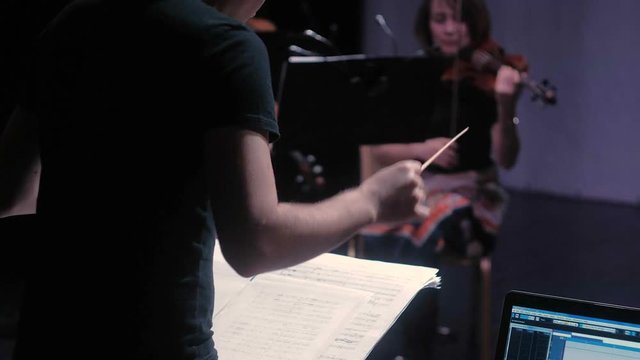 conductor of the symphony orchestra performs in a large hall