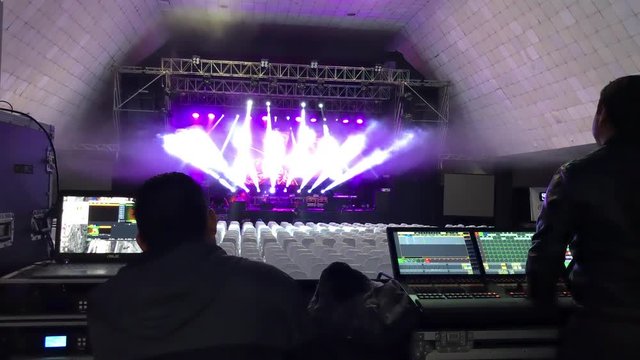 Engineers preparing lighting and video projections at empty venue before a show