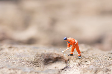 Miniature people: Men in uniform are using shovels to drill stones.