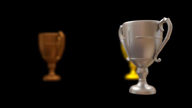 Animating rotating in circle bronze, silver and gold trophy while each is spinning around own axis. With matte finish surface, and shadow depth of field. Black background, mask included.
