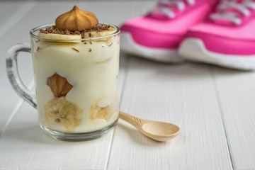 Shortbread cookies in a mug with banana pudding on a background of pink sneakers.
