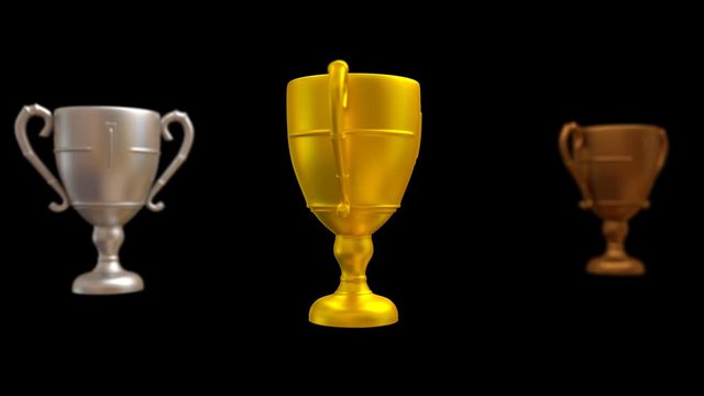 Animated plain silver, gold and bronze trophy with matte surface finish spinning against black background. Gold trophy in main focus. Isolated and loop able, mask included. Gold trophy in main focus.