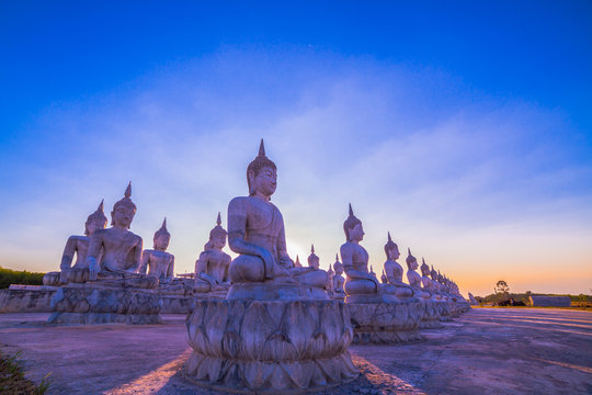 a lot of Buddha statues have many sizes are arranged in a row in the large yard of the place of religious activities.