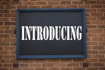Obraz premium Conceptual hand writing text caption inspiration showing announcement Introducing. Business concept for Introduction Start Intro Beginning written on frame old brick background with copy space