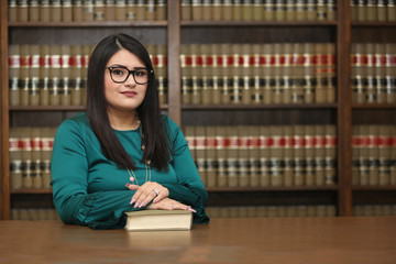 Portrait of a young attractive hispanic woman, women attorney in law library