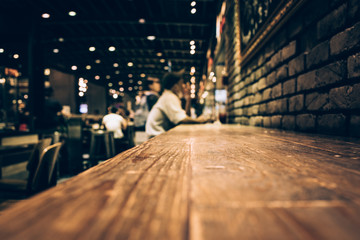 Blur of wood bar table in night cafe /selective focus