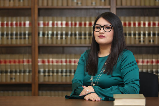 Portrait of a young attractive hispanic woman, women attorney in law library