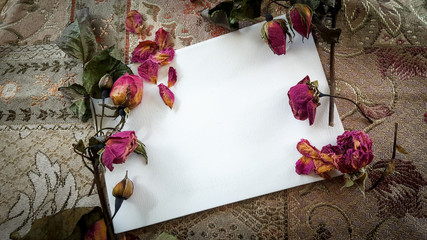 Dried rose buds and flowers with a card and room for text