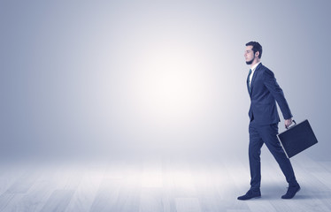 Businessman walking in front of an empty wall