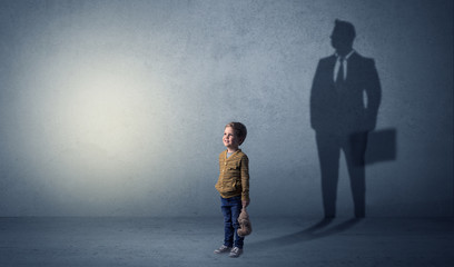 Little boy with businessman shadow - obrazy, fototapety, plakaty