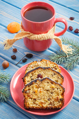 Cup of hot tea, fresh baked fruitcake for Christmas time and spruce branches