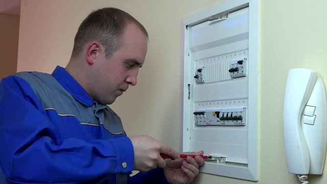 man electrician work on circuit breaker in client home. 4K