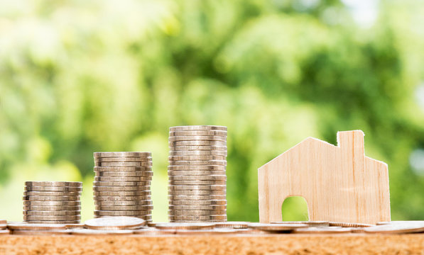 Wooden House model and step of coins stacks, money, saving and investment or family planning concept.