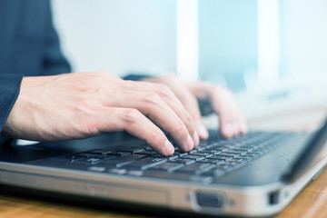 close up hand of businessman typing keyboard on laptop. business people and technology concept.