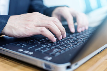 close up hand of businessman typing keyboard on laptop. business people and technology concept.