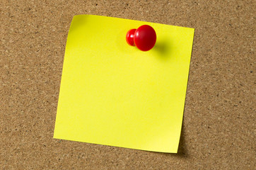Yellow note pad attached to corkboard
