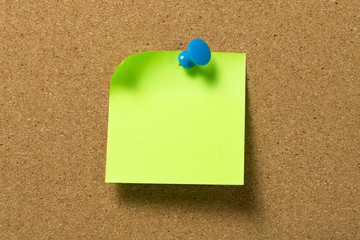 Green note pad attached to corkboard