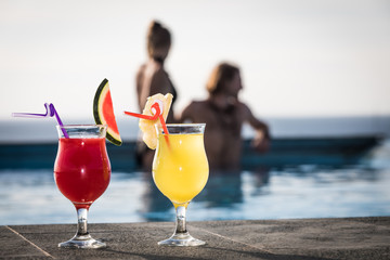 Couple drinking cocktails in swimming pool