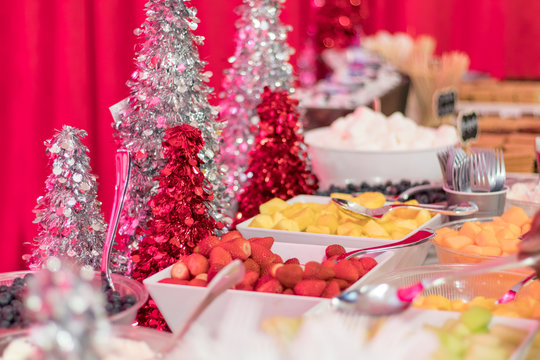 Holiday Party dessert buffet with assorted fresh fruit and festive red and silver decor