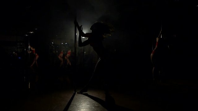 Silhouette sexy pole dance woman near the pole, slow motion.