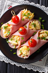 Delicious roll of ham stuffed with omelette close-up. Vertical top view