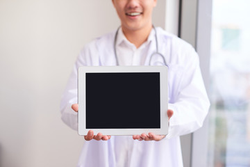 Asian male doctor shows his blank screen of computer tablet, close up