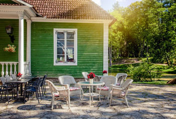 table and chairs next to the house, outdoor cafes, summer landscape
