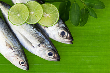 fish with lemon and leafs on banana leaves background,concept cooking background.