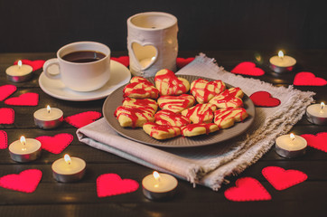 cookie-hearts, paper hearts, candles, boxes with presents and a Cup of black coffee, congratulation with Valentine's day.