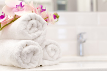 Obraz na płótnie Canvas Stack of towels with flower decor in a hotel room