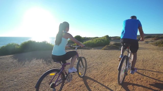 Young couple riding in bike near to the beach	