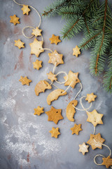 Homemade shortbread star shape sugar with sugar powder and  branch of fit-tree on thread over blue texture surface. Selektive focus.  Christmas or New Year background.  Top view with space.