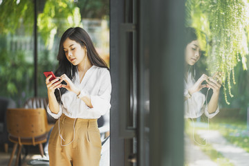 asian woman standing and using smart phone