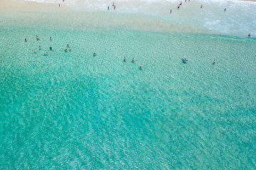 An aerial view of surfers waiting for a wave in the ocean on a clear day in Byron Bay 
