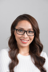 Obraz premium Close-up portrait of smiling confident businesswoman looking straight, isolated on grey background.