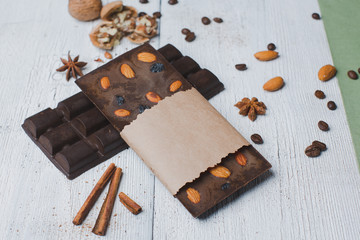 chocolate bar filled with cashew  nuts  lie old wooden table with cracked paint on the surface....